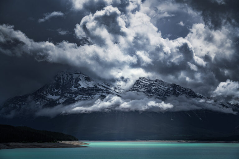 Monumental light-cloud atmosphere over Abraham Lake in Canada with Normandy and Ardennes Peak in the background