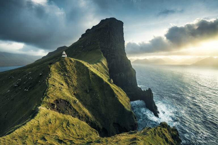 Northern End of the island Kalsoy at the Faroe Islands with atmospheric side light. The lighthouse stands picturesquely on the green overgrown cliffs.