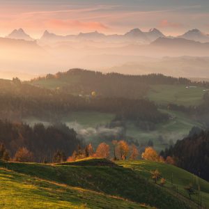 Wide view in the Swiss Emmental with a view of Alpine peaks in the early autumn morning light