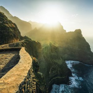 Hiking trail with gigantic mountain-sea backdrop in the golden sunset light on the north coast of Santo Antao - Cape Verde