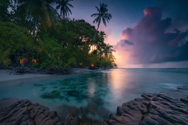 Abenteuerlich-romantische Küstenszene auf einer kleinen tropischen Insel im Nord-Nilandhe Atoll / Malediven im magischen Zwielicht des Abends
