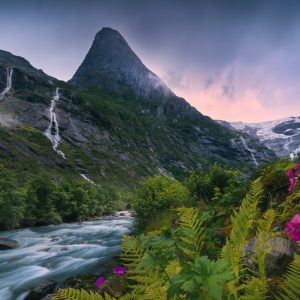 The largest glacier in mainland Europe in Jostedalbreen National Park in Norway with paradisiacal vegetation, waterfalls, a river course and a striking mountain.