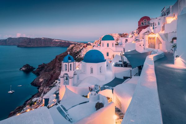 View over the white town of Oia on Santorini at dawn. Well-known viewpoint with the three blue domes.